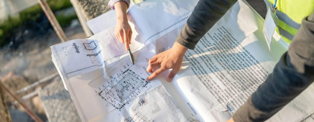 Two people reviewing a printed construction blueprint
