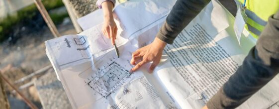 Two people reviewing a printed construction blueprint
