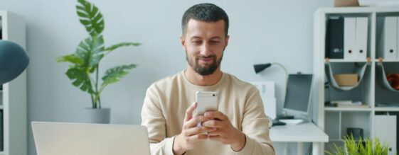 Man in an office on phone using VoIP call features